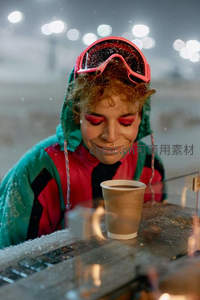 滑雪女孩捧热饮微笑迎雪花飘落