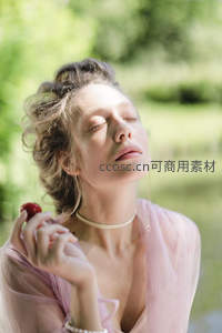 阳光下闭眼享受浆果的女子