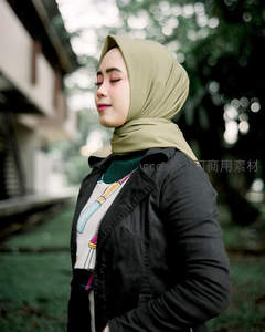 戴头巾女子闭目微笑享受林间清风