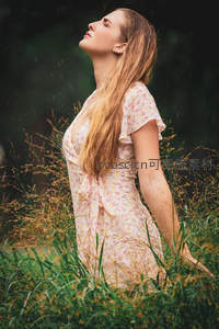 雨中少女仰面微笑，花裙草丛共舞