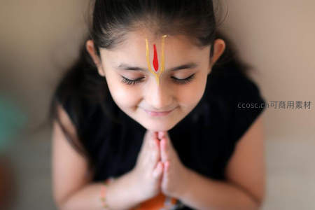 额头绘彩的小女孩虔诚合十祈祷