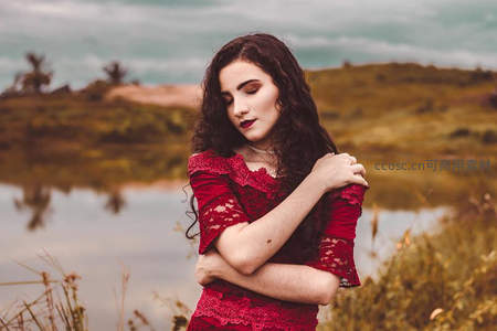 湖畔红裙女子抱臂凝望远方