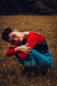 田野中蜷缩沉思的红衣女子