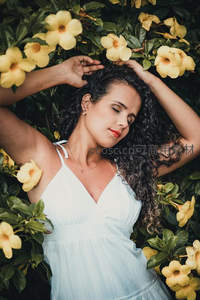 花丛中白衣女子闭目享受自然之美