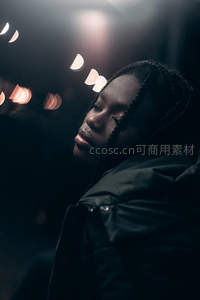 夜色中闭目女子，城市光斑映衬静谧面容