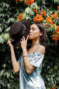 绿意花丛中少女轻吻礼帽的温柔瞬间