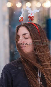 圣诞发箍少女闭眼微笑，雪花纷飞