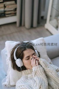 居家女孩戴耳机小憩，毛衣温暖