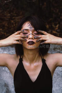 神秘女子闭目遮面，面部绘有符号