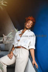 蓝墙光影下的时尚女郎优雅休憩瞬间