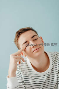青年闭目轻触眼角，神情宁静放松