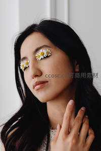 女子闭目贴雏菊，手抚颈项显柔美