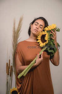 女子怀抱向日葵闭目沉思