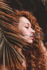 棕榈叶下的红发少女闭目沉思