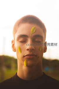 少年闭眼享受落叶轻拂脸颊