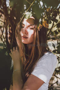 阳光穿透树叶洒在少女脸庞