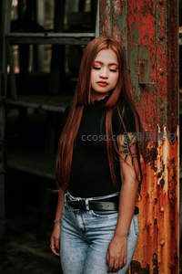 红发少女倚靠锈蚀铁柱凝视前方