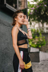 街头女孩以手遮阳闭目感受微风