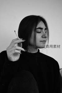 黑白光影中的沉思女子手持香烟
