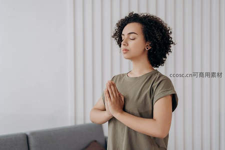 卷发女子闭目冥想双手合十