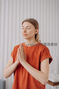 金发女子穿橙衣闭目合掌冥想