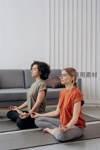 两位女性在室内瑜伽垫上静心冥想
