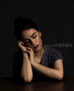 暗调光影中女子托腮沉思