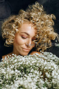 卷发女子怀抱满天星，温柔梦境般画面