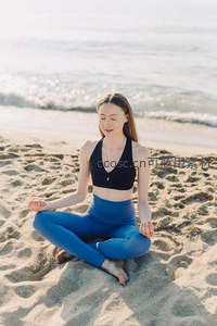 沙滩瑜伽，蓝装女子迎海风冥想