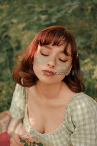 绿意盎然中闭目养神，格子衫少女静享时光