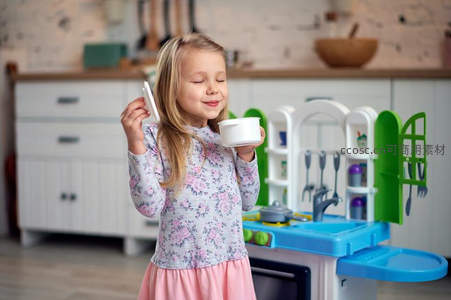 小女孩在玩具厨房里快乐地假装做饭