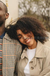 卷发女子依偎伴侣展露幸福微笑