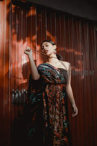 光影斑驳中，女子轻抚发丝展现优雅姿态