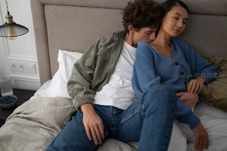 情侣依偎床上，温馨卧室静谧时刻