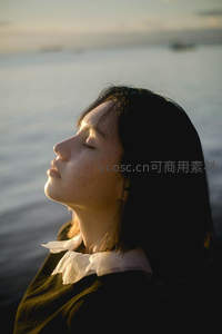 海边闭目享受夕阳的宁静时刻