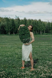 女子草地持镜映照绿意自然风光