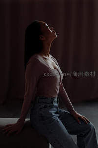 暗调光影中女子仰首沉思静谧