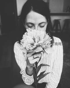 黑白影像中女子轻嗅牡丹花香，恬静安然