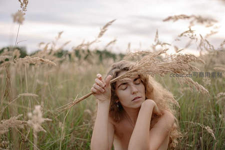 金发少女躺卧草丛手持麦穗