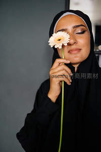 穆斯林女子手持花朵遮眼