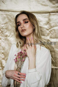 金发女子手捧粉花闭目养神