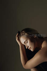 光影交错，金发女子沉思侧影