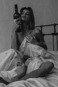 黑白影像中女子床上独酌红酒