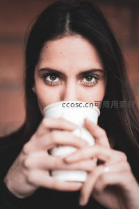 女子双手捧杯凝视镜头