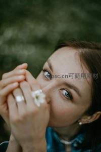 女子手捧白花轻嗅，眼神温柔如水