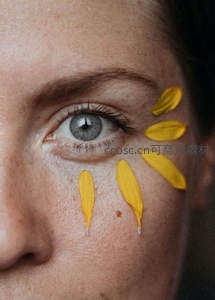 灰眸旁贴饰黄色花瓣的艺术脸庞