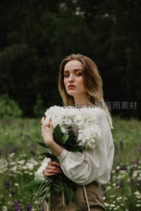 花田中怀抱白芍药的自然少女