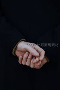 深色大衣下紧握的双手显沉稳