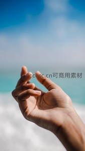 海边阳光下轻盈托举的手掌