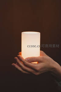 双手捧着温暖的发光圆柱体